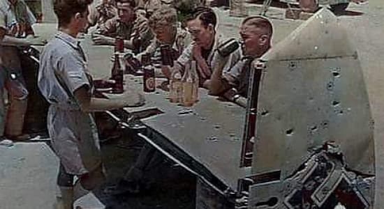 Des soldats anglais boivent un verre sur l'empennage d'un Bf-110 transformé en bar
