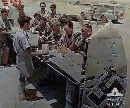 Des soldats anglais boivent un verre sur l'empennage d'un Bf-110 transformé en bar