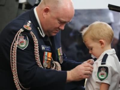 Fils d’un pompiers australien mort au feu recevant une médaille posthume.